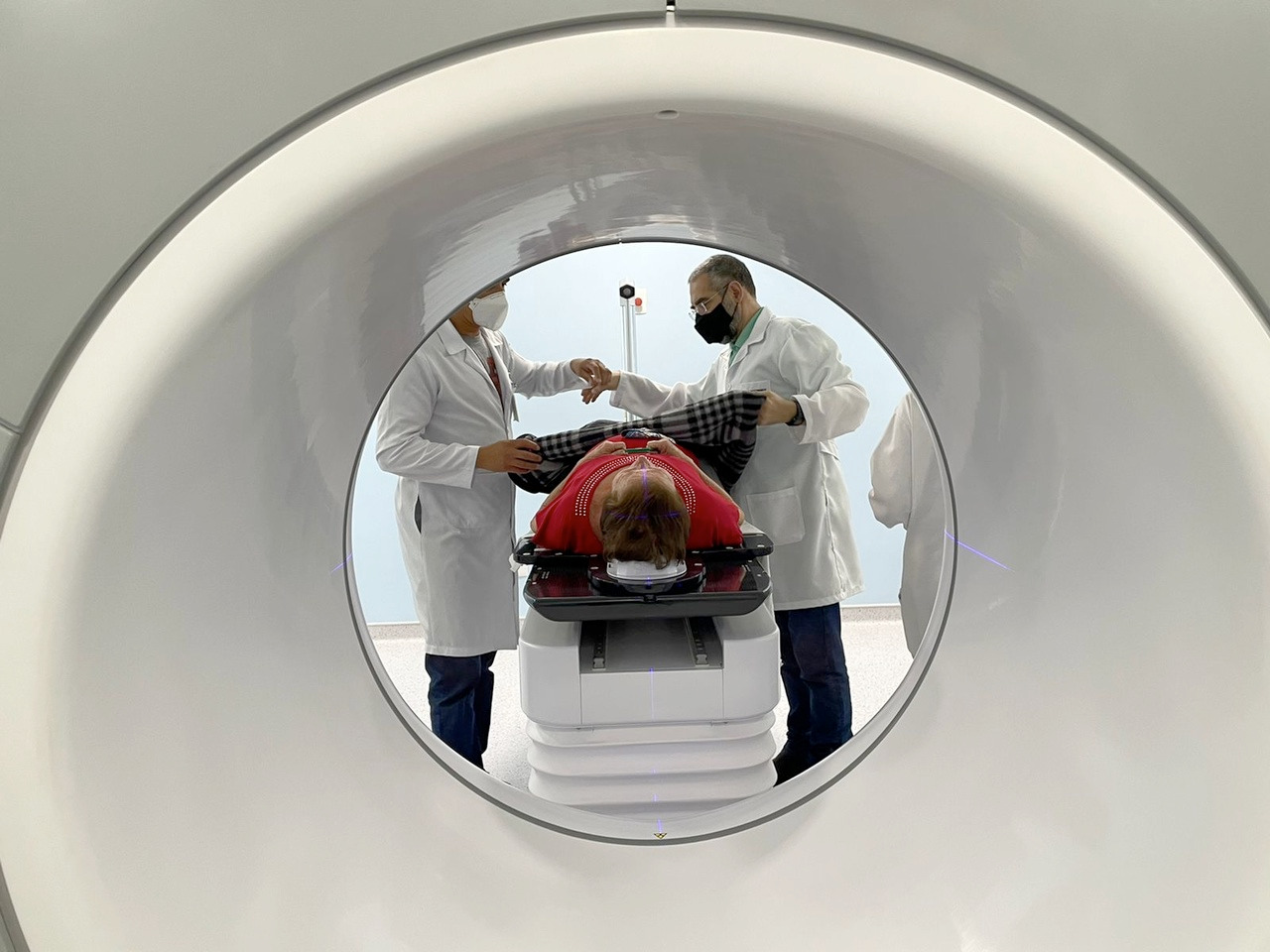 Paciente deitado em uma maca é preparado para entrar em um aparelho de radioterapia, um acelerador linear. Esse é um dos equipamentos que o Agora Tem Especialistas oferece para hospitais do SUS, além de outras medidas
