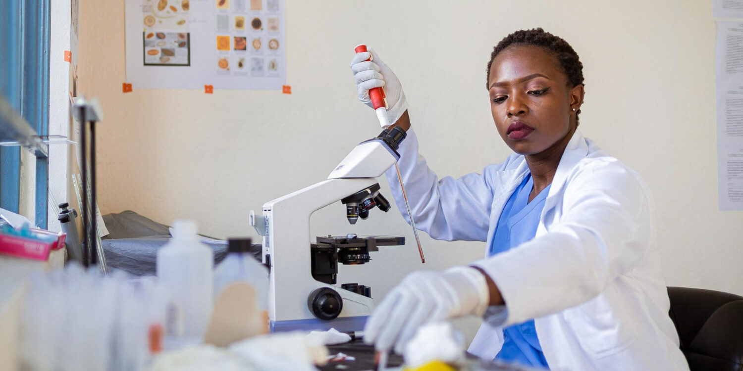 Uma cientista trabalhando com seu microscópio em um laboratório. Experiência de ciência aberta pode ajudar a democratizar o acesso a medicamentos